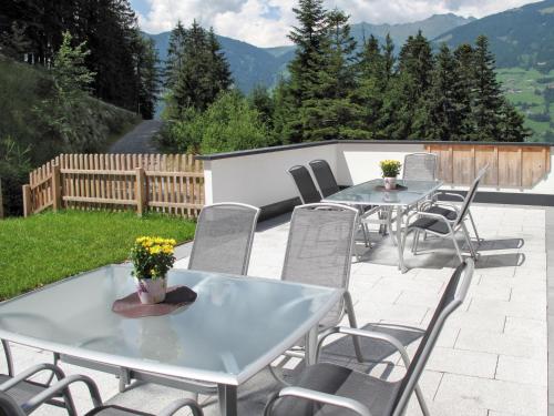 duas mesas e cadeiras num pátio com montanhas em Apartment Edelweiss - MHO527 by Interhome em Ramsau im Zillertal