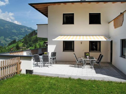 um pátio com cadeiras e uma mesa ao lado de uma casa em Apartment Edelweiss - MHO527 by Interhome em Ramsau im Zillertal