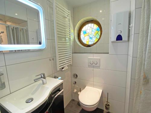 a bathroom with a sink and a toilet and a mirror at FeWo "Hoffi" am Waldesrand in Baabe