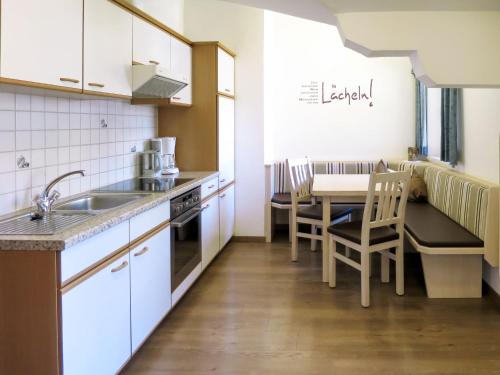 kuchnia ze zlewem i stołem z krzesłami w obiekcie Apartment Heisenhaus-2 by Interhome w mieście Ramsau im Zillertal