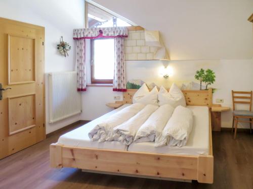 sypialnia z dużym łóżkiem z białymi poduszkami w obiekcie Apartment Heisenhaus-2 by Interhome w mieście Ramsau im Zillertal