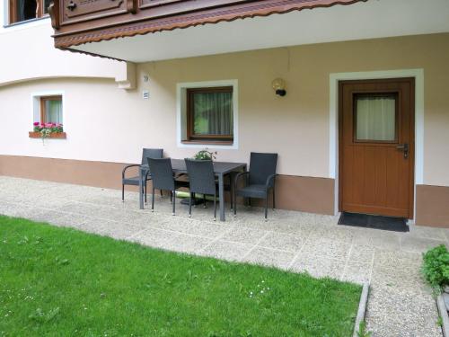 a patio with a table and chairs next to a house at Apartment Daheim – Edelweiß by Interhome in Plangeross