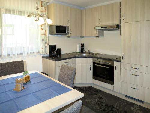 una cucina con armadi bianchi e tavolo con sedie di Apartment Daheim – Edelweiß - PZT382 by Interhome a Plangeross