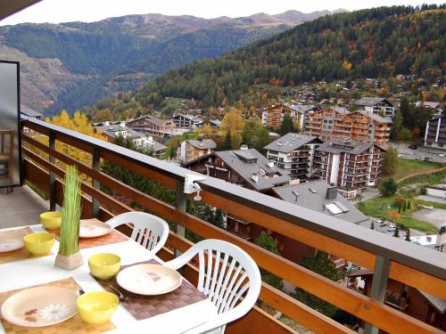 a table and chairs on a balcony with a view at Apartment Nid d'aigle E1 by Interhome in Nendaz