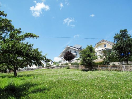 a field of grass with houses in the background at Apartment Leni - FIE151 by Interhome in Fliess