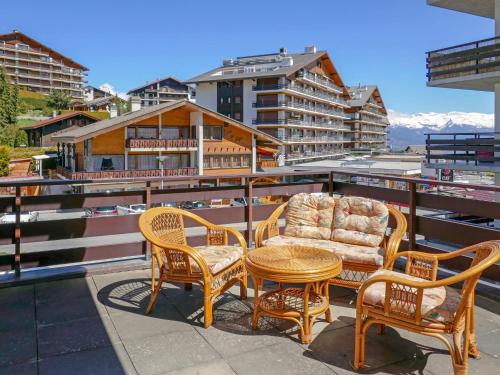 un patio avec une table et des chaises sur un balcon dans l'établissement Apartment Zanfleuron A1 by Interhome, à Nendaz