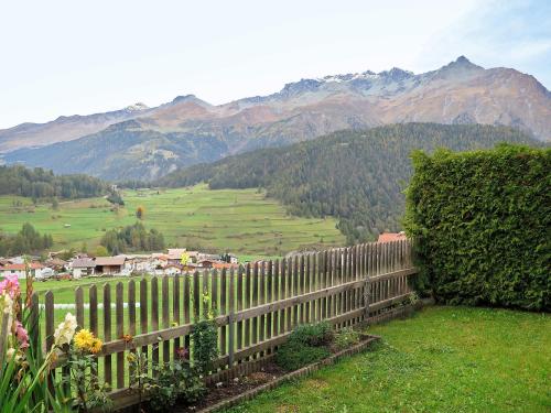 a fence in a field with mountains in the background at Apartment Steinwender by Interhome in Nauders