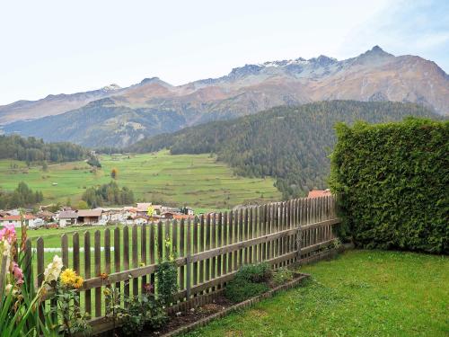 a fence in a field with mountains in the background at Apartment Steinwender - NDR140 by Interhome in Nauders