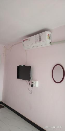 a white wall with a tv on a wall at Kulswami Cottage Alibag in Alibaug