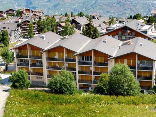 ein Apartmenthaus auf einem Hügel mit Häusern in der Unterkunft Apartment Montfort 9A by Interhome in Nendaz