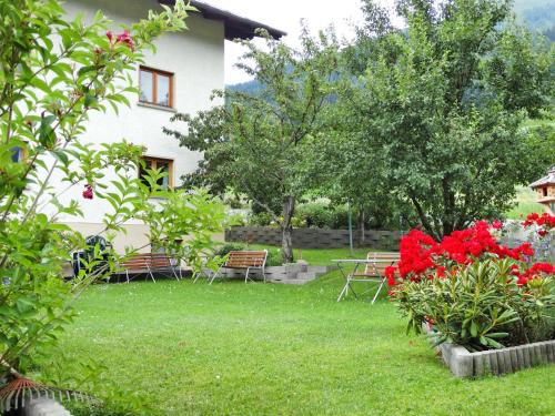 un jardín con sillas y flores frente a una casa en Apartment Tyrol by Interhome, en Tobadill
