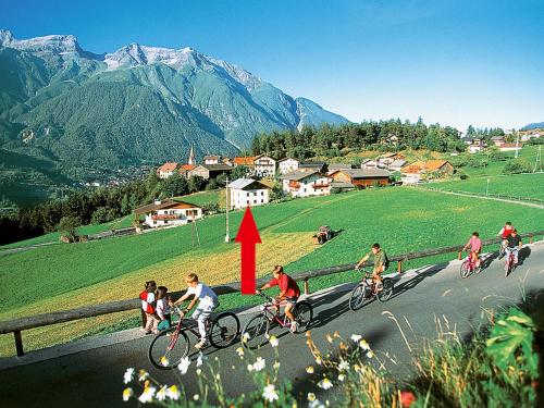 un gruppo di persone che vanno in bicicletta lungo la strada di Apartment Tyrol - TDL125 by Interhome a Tobadill