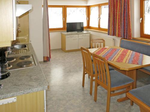 eine Küche und ein Esszimmer mit einem Tisch und Stühlen in der Unterkunft Apartment Elfriede - SZU123 by Interhome in See
