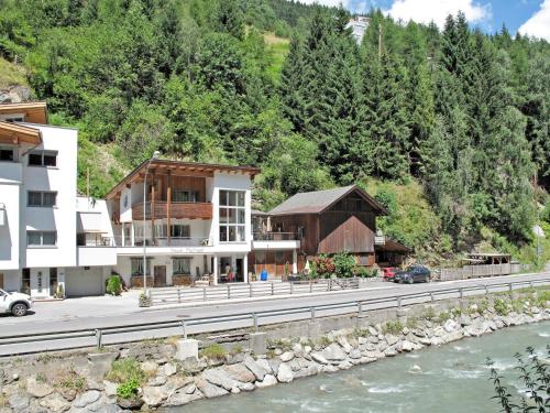 a building on the side of a road next to a river at Apartment Michael by Interhome in Kappl