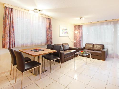 ein Wohnzimmer mit einem Sofa, einem Tisch und Stühlen in der Unterkunft Apartment Roger-2 by Interhome in Zermatt