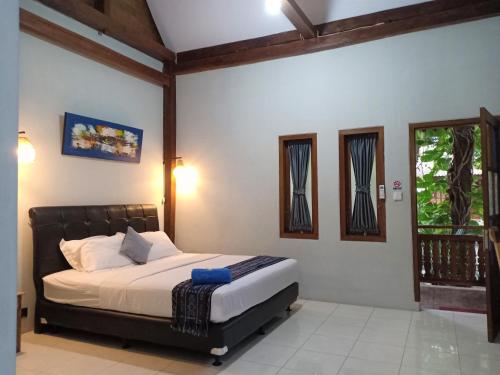 ein Schlafzimmer mit einem Bett und einem Fenster in der Unterkunft Bata Merah Homestay in Banyuwangi