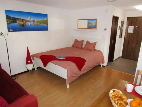 um quarto com uma cama com um edredão vermelho em Apartment Sungold-1 by Interhome em Zermatt