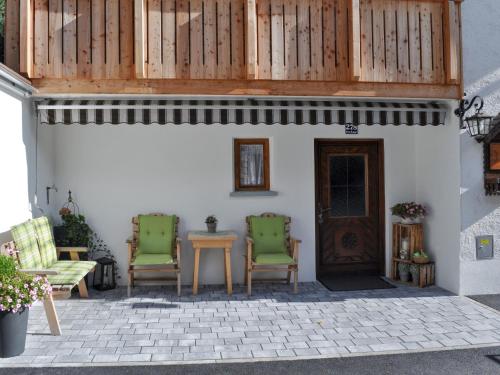 patio z 2 krzesłami, stołem i drzwiami w obiekcie Holiday Home Schönblick - KPL643 by Interhome w mieście Kappl