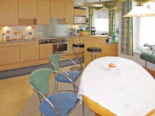 une cuisine avec une table et des chaises. dans l'établissement Apartment Schmiedbach - STA255 by Interhome, à Sankt Anton am Arlberg