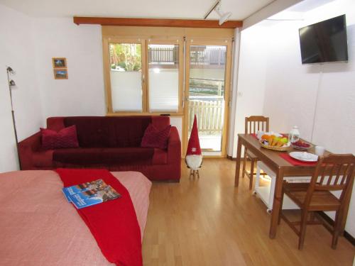 sala de estar con sofá rojo y mesa en Apartment Sungold-2 by Interhome, en Zermatt