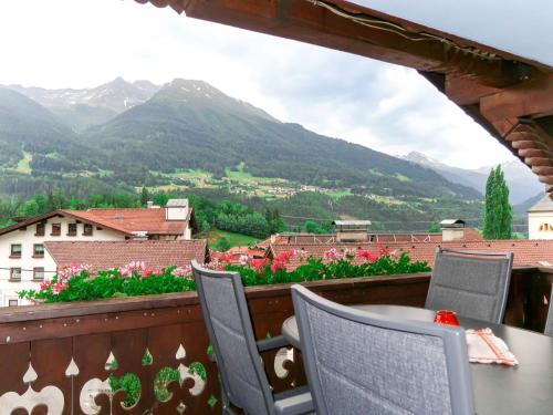 una mesa y sillas en un balcón con montañas en Apartment Huber - GIT110 by Interhome, en Grins