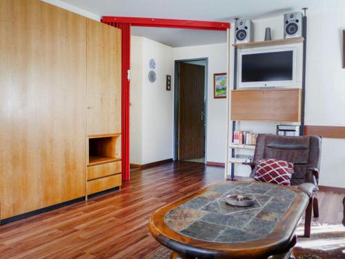 a living room with a table and a tv at Apartment Dianthus-1 by Interhome in Zermatt