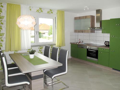 eine Küche mit grünen Schränken und einem Tisch mit Stühlen in der Unterkunft Apartment Fuchs - DON160 by Interhome in Donnerskirchen