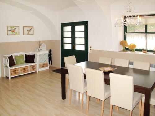 jadalnia ze stołem i białymi krzesłami w obiekcie Holiday Home Hofgasse - MOE112 by Interhome w mieście Mörbisch am See