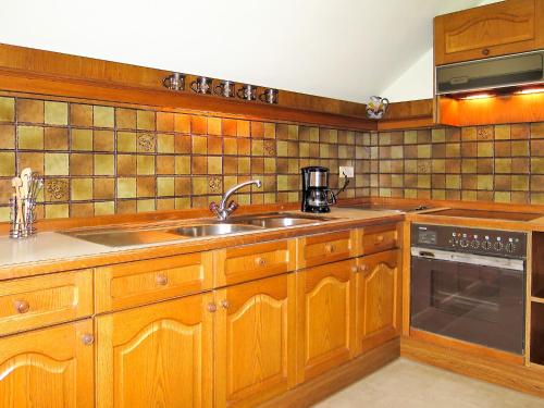a kitchen with wooden cabinets and a sink at Apartment Moser-1 by Interhome in Stein an der Enns