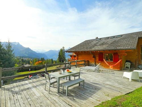 um deque de madeira com uma mesa e cadeiras num camarote em Chalet Saint Piran by Interhome em Villars-sur-Ollon