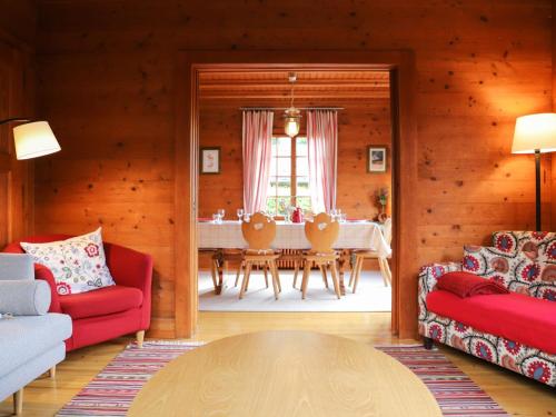 ヴィラール・シュル・オロンにあるChalet Chalet Merymont by Interhomeのリビングルーム(赤い椅子、テーブル付)