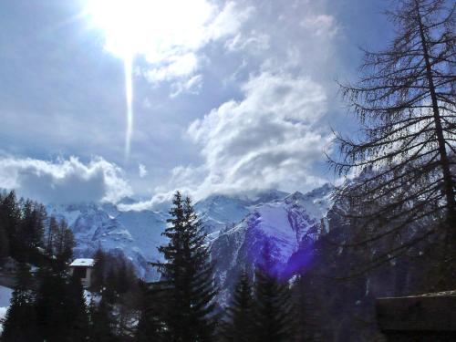a view of a snow covered mountain with the sun at Apartment Lärchenheim by Interhome in Gasenried