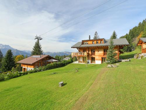 a large house on a hill with a green field at Chalet Khamariah by Interhome in Villars-sur-Ollon