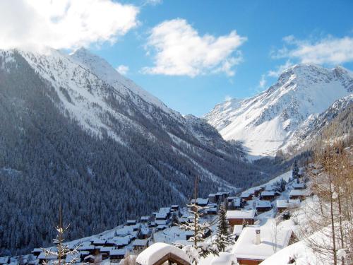 a snow covered mountain with houses and snow covered mountains at Chalet Les Clarines by Interhome in Grimentz