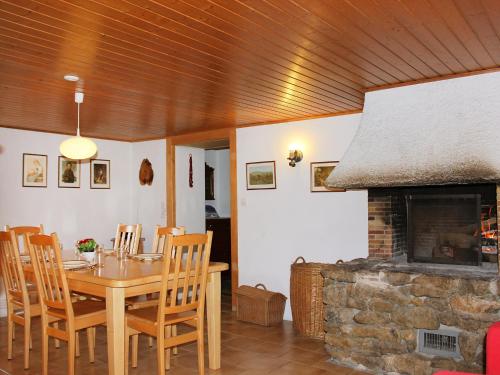 une salle à manger avec une table et une cheminée dans l'établissement Apartment Les Grangettes by Interhome, à Auberson