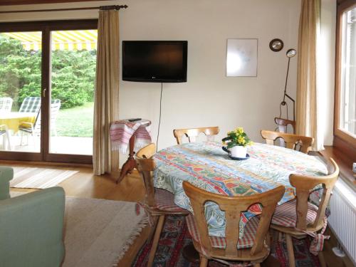 una sala da pranzo con tavolo, sedie e TV di Holiday Home Reier - BOD130 by Interhome a Seeboden