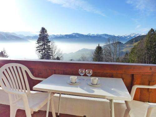 a white table and chairs on a balcony with a view at Apartment Les Girolles B14 by Interhome in Villars-sur-Ollon