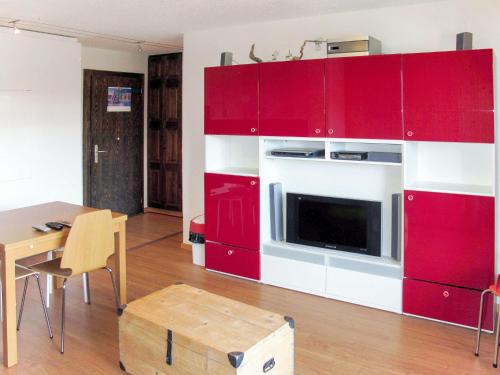a living room with red cabinets and a dining room table at Apartment Mirabeau by Interhome in Les Collons