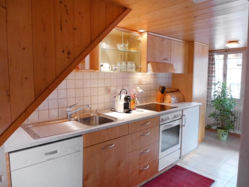 uma cozinha com um lavatório e um fogão em Chalet Hüsli by Interhome em Brienzwiler