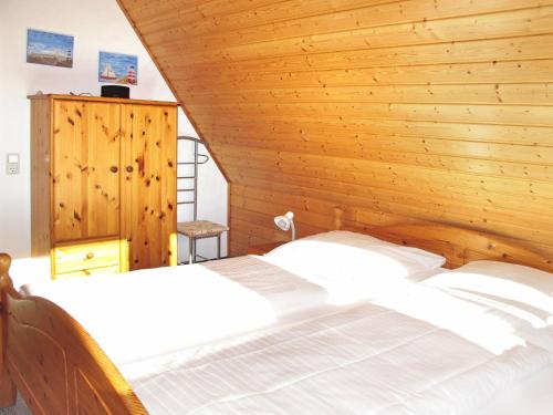 ドルム・ノイフェルトにあるHoliday Home Cuxland Ferienpark-1 by Interhomeの木製の壁のベッドルーム1室(大型ベッド1台付)