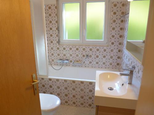 a bathroom with a sink and a toilet and a window at Apartment Andrea B15 by Interhome in Vermala