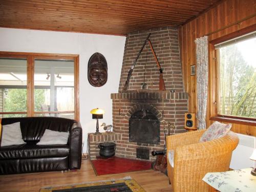 a living room with a couch and a fireplace at Chalet Fietz by Interhome in Nienkattbek