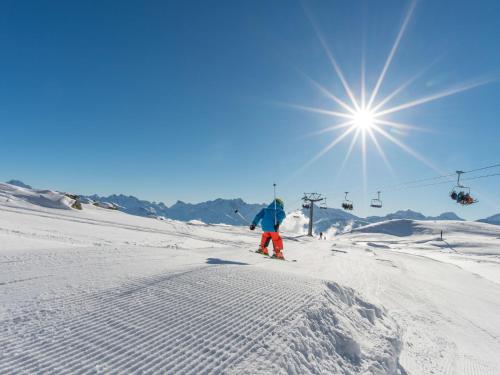 a person skiing down a snow covered slope with a ski lift at Apartment Aragon B47 by Interhome in Ernen