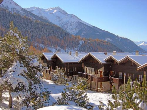 a house in the snow with mountains in the background at Apartment Aragon M86 by Interhome in Fiesch