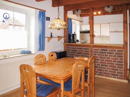 eine Küche und ein Esszimmer mit einem Holztisch und Stühlen in der Unterkunft Holiday Home Kitowski by Interhome in Hooksiel