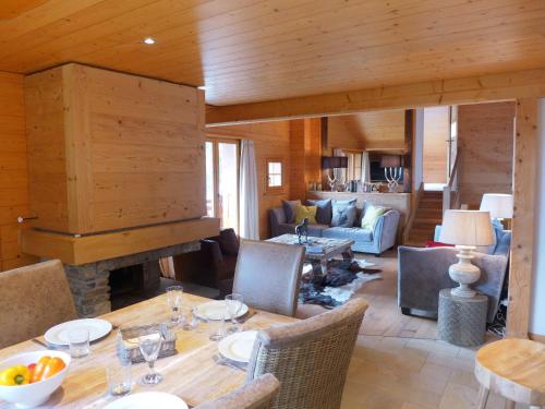 ein Wohnzimmer mit einem Tisch und einem Kamin in der Unterkunft Apartment Le Faucon 8 by Interhome in Villars-sur-Ollon