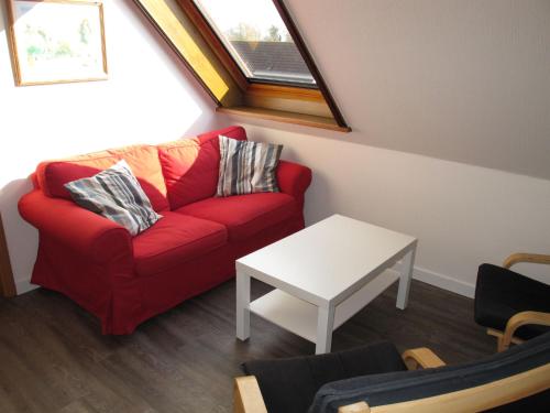 FriederikensielにあるApartment Landskron-2 by Interhomeのリビングルーム(赤いソファ、テーブル付)