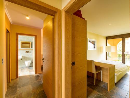 a bedroom with a bed and a desk in a room at Apartment Giardino by Interhome in Ascona