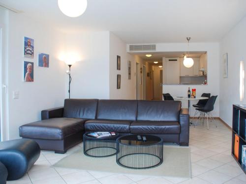 sala de estar con sofá de cuero y cocina en Apartment Coris by Interhome, en Vira