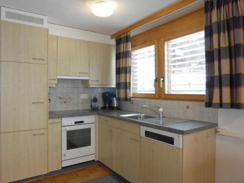 una cocina con armarios de madera y fregadero en Apartment Rose Apt- Y by Interhome, en Wengen